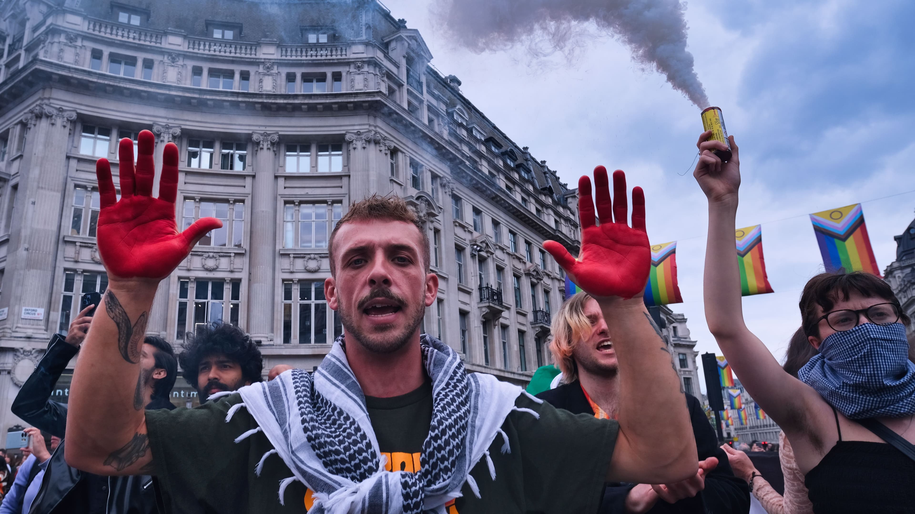 Demonstration, ein Mann hält seine rot gefärbten Hände in die Höhe.